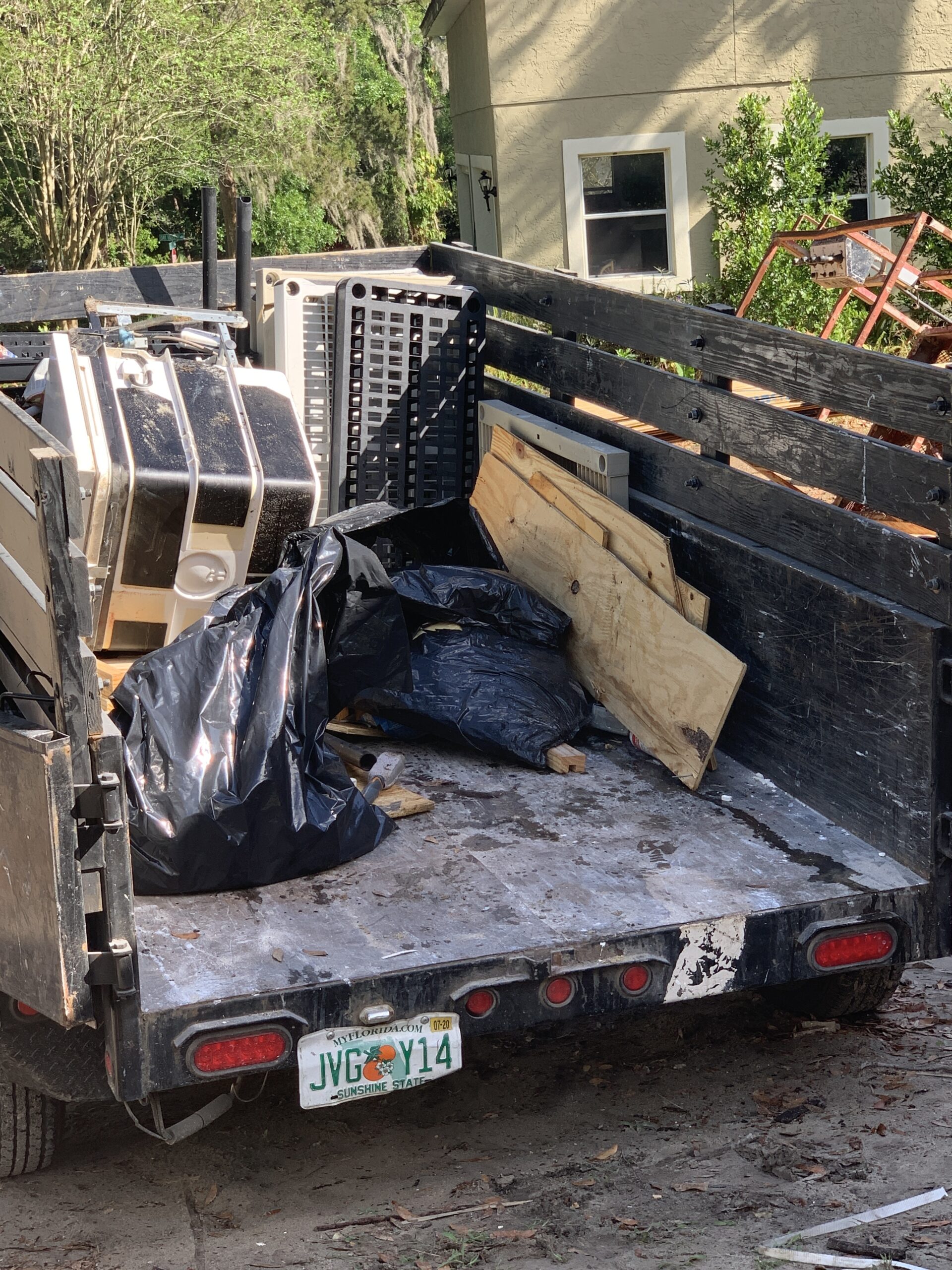 Junk Busters trailer loaded with bagged waste wood and outdoor cleanup debris
