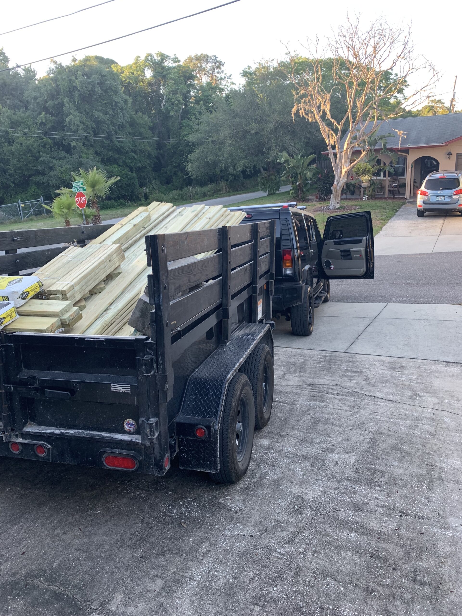 Junk Busters dump trailer loaded with wood and bulky debris during a Tampa Bay property cleanup