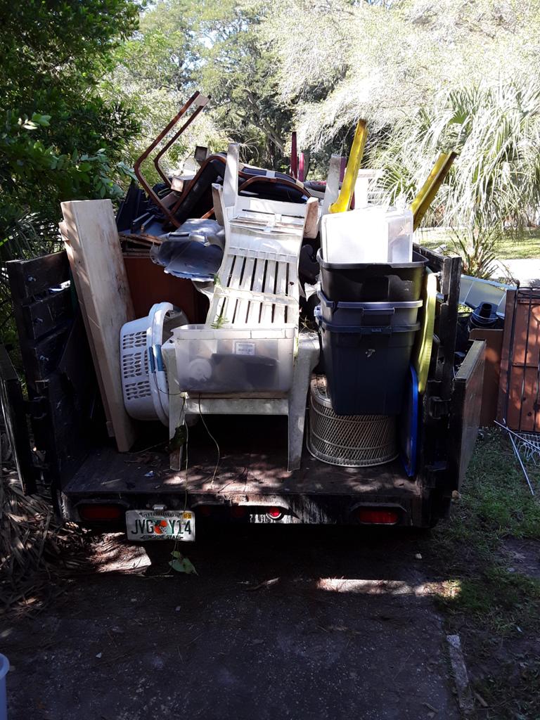 Junk Busters trailer loaded with appliances equipment and bulky household items